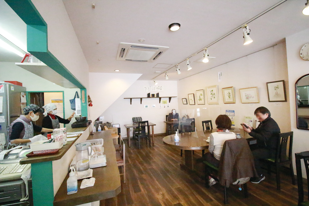 喫茶店に地域住民が集まって談笑している様子の画像