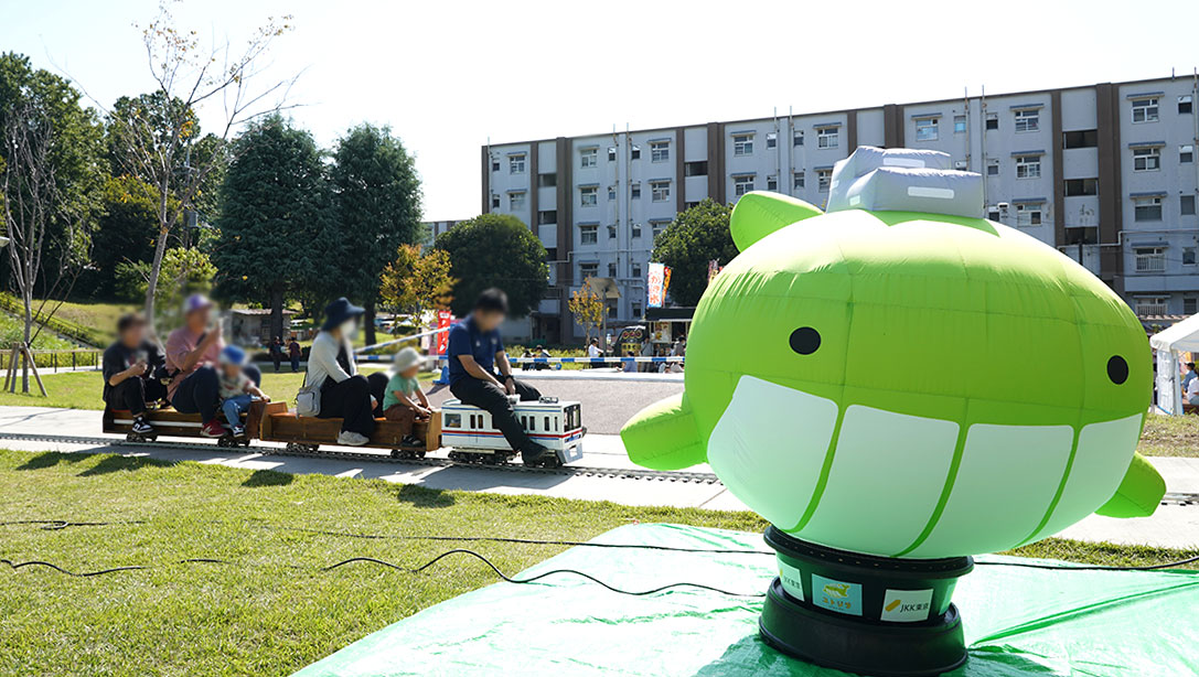 ミニ鉄道とJKKのイメージキャラクター「ユトジラ」の写真