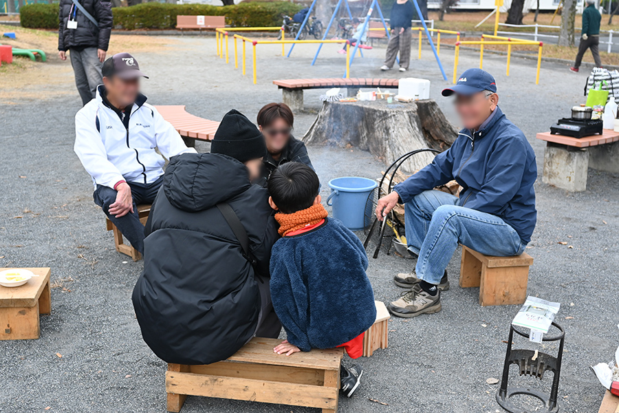 焚き火を囲んで生まれる多世代交流の様子