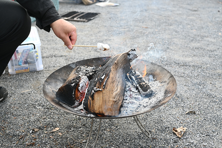 焚き火を囲んでマシュマロを焼く様子