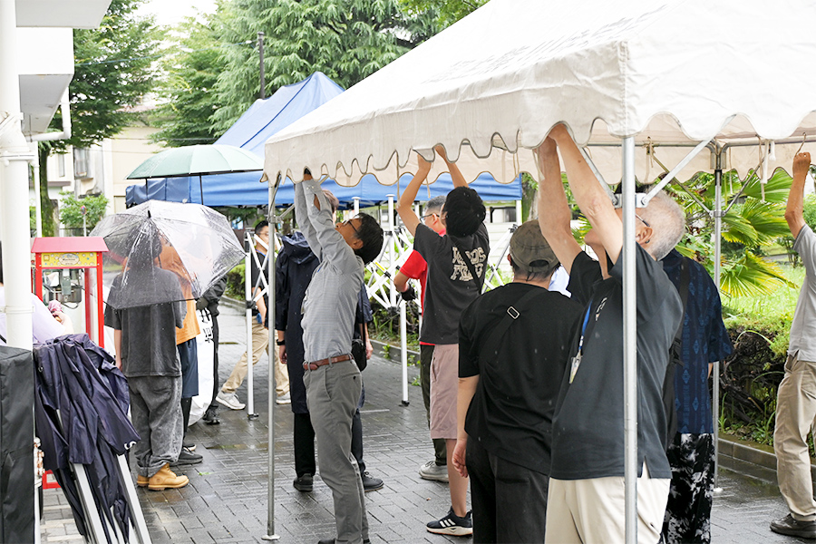 降りしきる雨にも負けず、みんなでテントを設営の様子